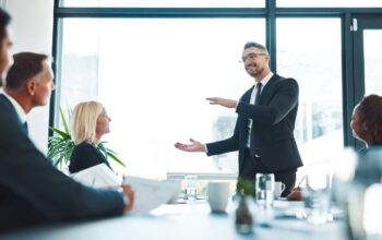 Mann erklärt im Business-Meeting Taktiken aus dem Verhandlungstraining vor Führungskräften