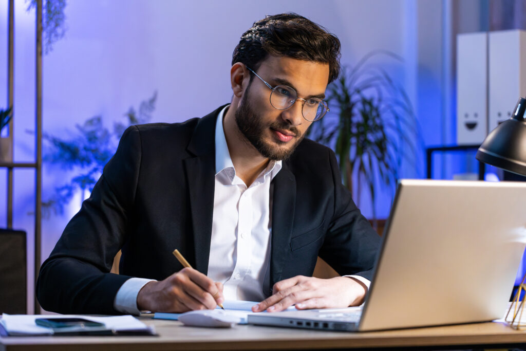 Teilnehmer bereitet sich mit Laptop auf Verhandlungstraining und Gesprächsszenarien vor