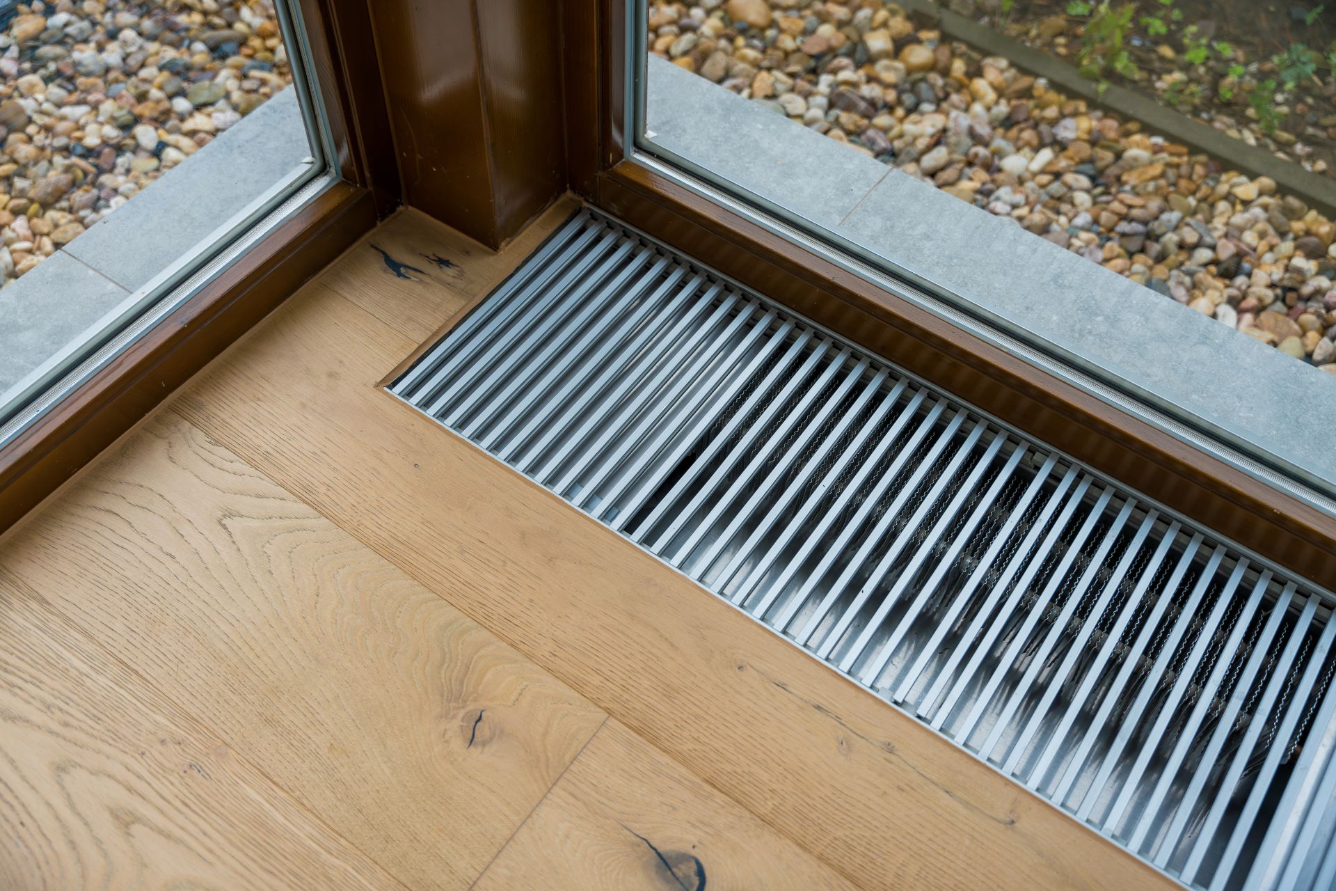 Heizgitter am Fenster im Holzboden integriert
