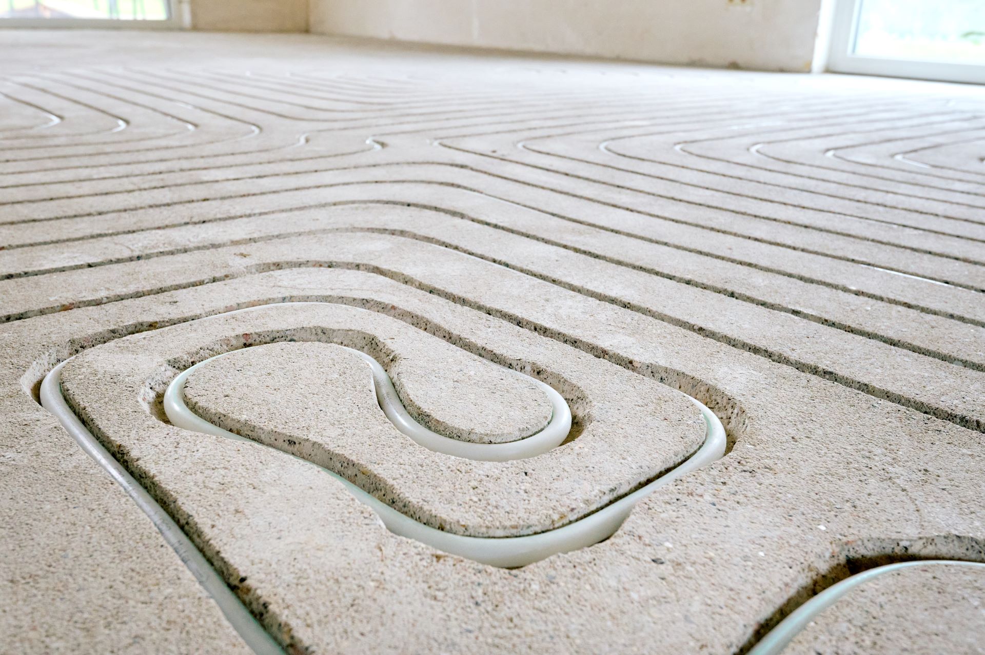 Gefräste Fussbodenheizung im Estrich mit verlegten Heizrohren