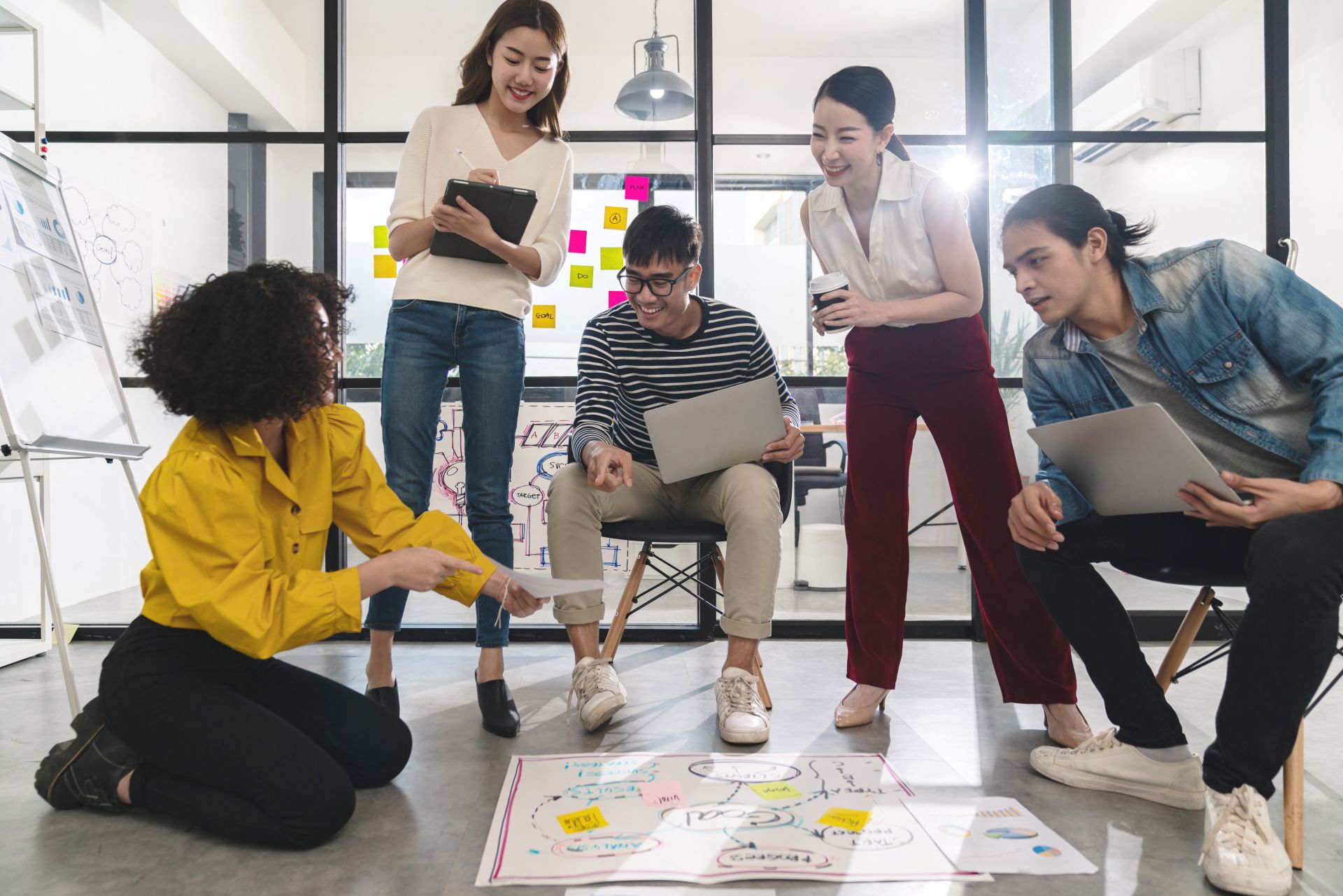 Ein diverses Team arbeitet gemeinsam in einem Kreativworkshop an einem Konzept – Symbol für Zusammenarbeit, Beteiligung und gesunde Unternehmenskultur.
