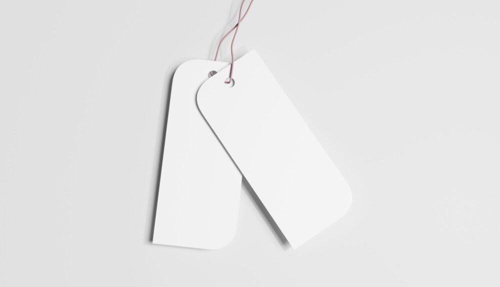 Zwei schlichte Haengeetiketten auf hellem Hintergrund als Symbol fuer klare Kennzeichnung und reduzierte Gestaltung im Business-Kontext