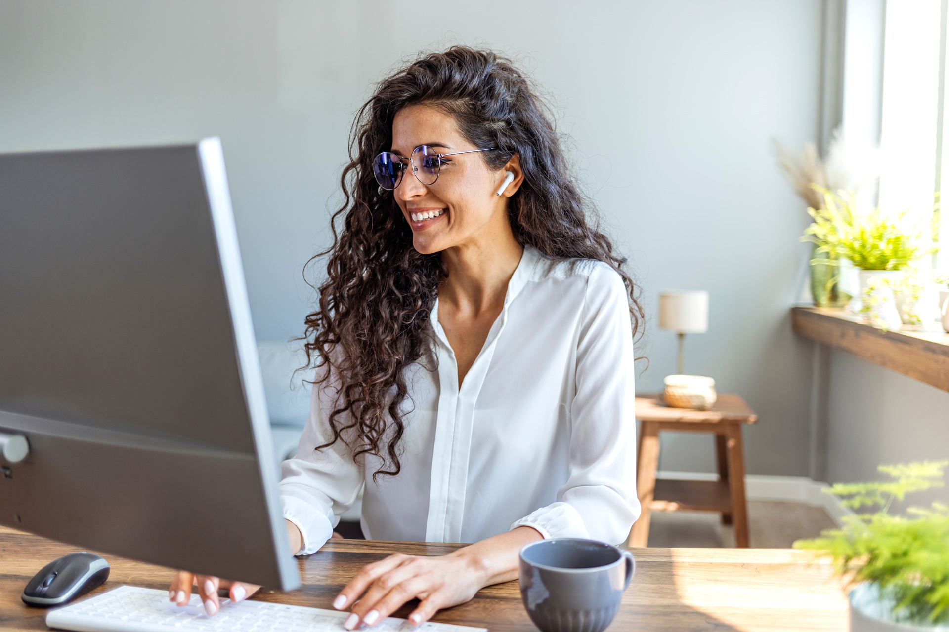 Frau arbeitet konzentriert am Computer im Homeoffice | höhenverstellbar Schreibtisch