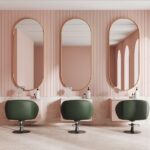 Moderner Friseursalon mit eleganter Klick Vinyl Marmoroptik und stilvollen grünen Sesseln vor rosafarbener Wandgestaltung