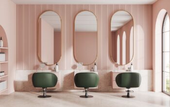 Moderner Friseursalon mit eleganter Klick Vinyl Marmoroptik und stilvollen grünen Sesseln vor rosafarbener Wandgestaltung