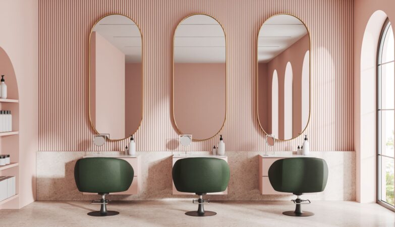 Moderner Friseursalon mit eleganter Klick Vinyl Marmoroptik und stilvollen grünen Sesseln vor rosafarbener Wandgestaltung