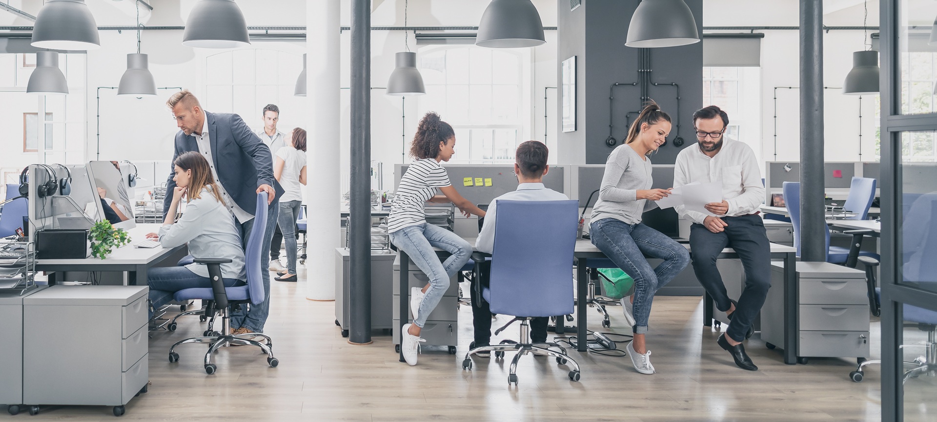 Mitarbeiter arbeiten gemeinsam in offenem Büro | höhenverstellbar Schreibtisch